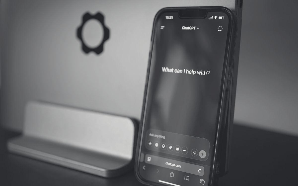 Celular apoiado em uma mesa exibindo a tela inicial do ChatGPT